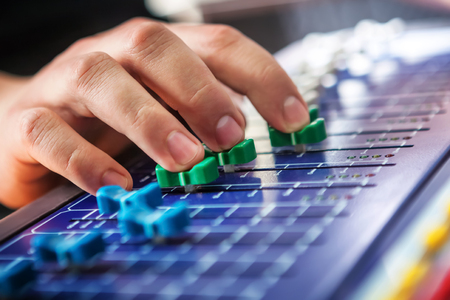 Professional audio engineer adjusting mixing concole.の写真素材