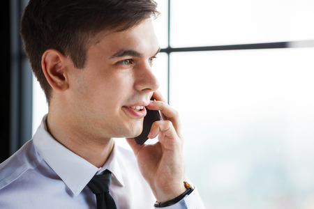 Portrait of young handsome businessman talking on the phone.の写真素材