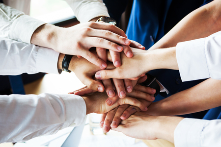 Closeup of a group of businesspeople joining their hands together.の写真素材