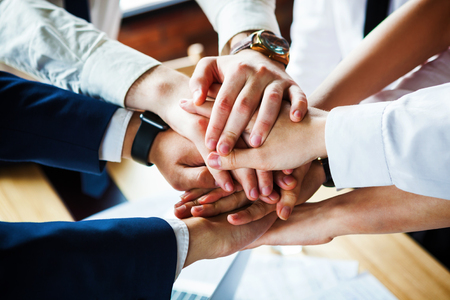 Closeup of a group of businesspeople joining their hands together.の写真素材