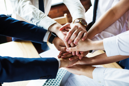 Closeup of a group of businesspeople joining their hands together.の写真素材