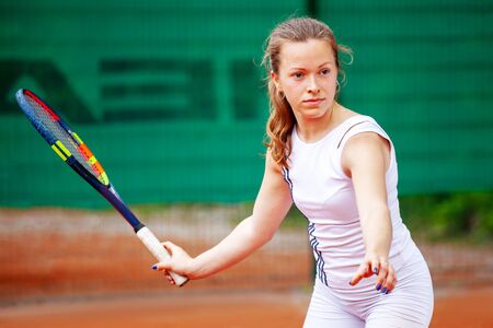 Young beautiful female tennis player playing tennis.の写真素材