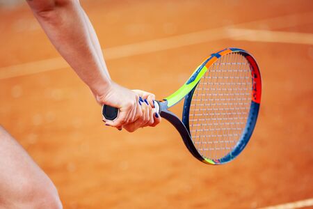 Close up female tennis player hitting two-handed backhand.の写真素材