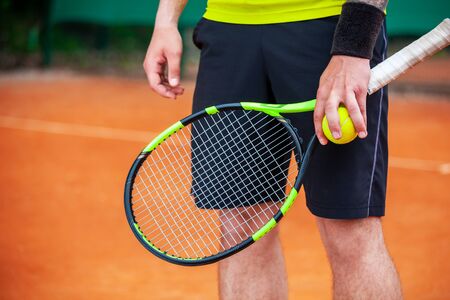 Close up male tennis player holding racket and ball.の写真素材