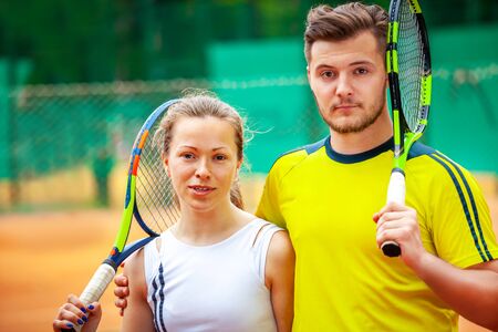 Portrait of two tennis players posing looking at camera.の写真素材