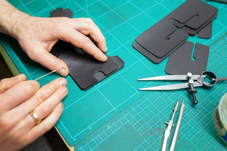 Leather Craftsman working with leathet. Making a wallet.の写真素材