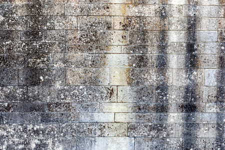 Old weathered wall made of grey bricks.の写真素材