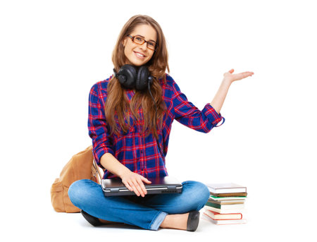 Portrait of happy student pointing on copy space isolated on white background.の写真素材