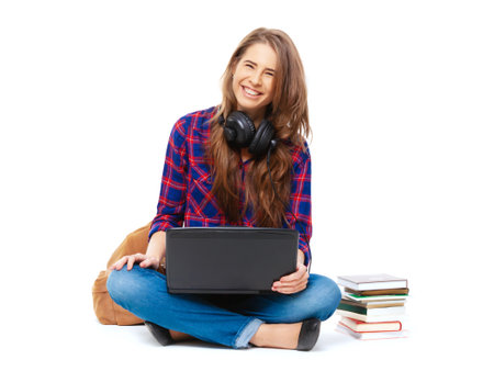 Portrait of happy female student sitting isolated on white background.の写真素材