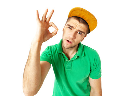 Cool looking young guy showing OK sign standing against white background. Wide angle lens effect.の写真素材