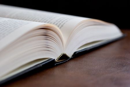 Hardcover book opened on a leather desk