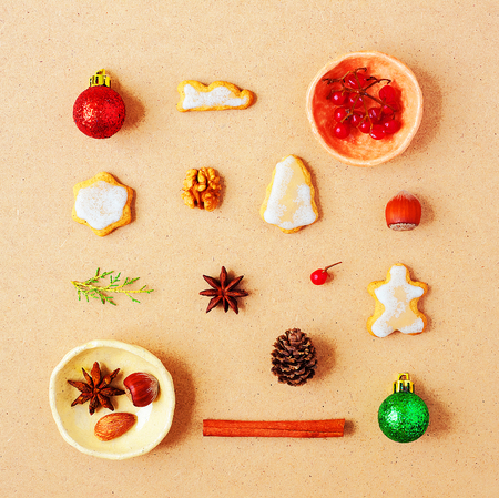 Creative Christmas pattern with traditional ginger cookies, nuts and Christmas decorations on warm pastel backgroundの写真素材