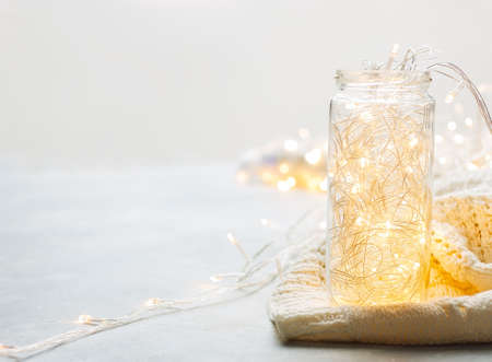 Christmas garland in jar and white plaid on grey background. Christmas, winter, new year concept. Banner, card mockup. Flat lay, top view, copy spaceの写真素材
