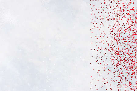Red confetti on grey background. Christmas, winter, new year texture. Flat lay, top view, copy spaceの写真素材