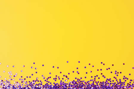 Violet confetti on yellow. Colorful Christmas or holiday backgroundの写真素材