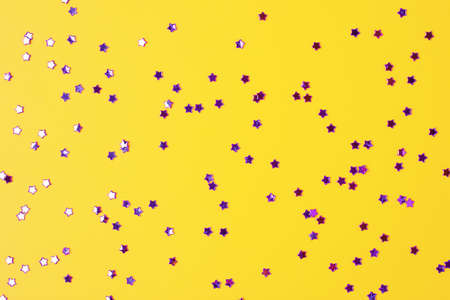 Violet confetti on yellow. Colorful Christmas or holiday backgroundの写真素材