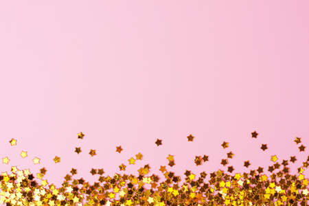 Golden confetti on pink. Colorful Christmas or holiday background
