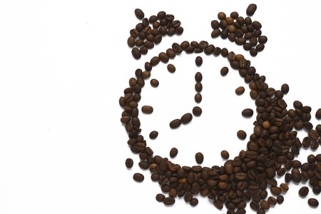 Alarm clock 8 AM arranged from roasted coffee beans. Time to awake drink espresso isolated on white...