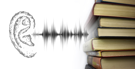 Stack of multicolored books and sound audio wave to human ear. Listen audiobooks online education technology concept. Old textbooks stacked on each other. White backgroundの写真素材