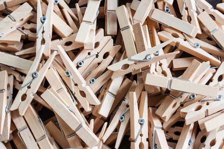 wooden clothespins piled on the floor and dark wood.の写真素材