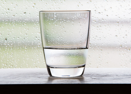 Glass with half a glass of water scenes with condensation glass.の写真素材