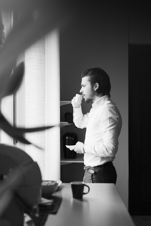 businessman has a coffee break in officeの写真素材