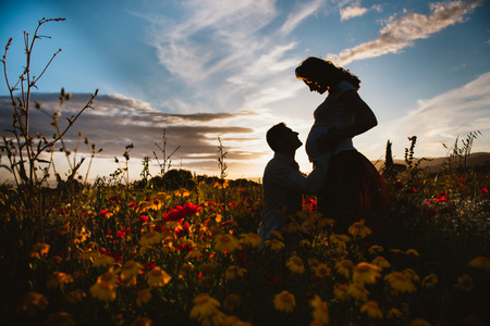 silouette of a couple waiting for a baby, at sunsetの写真素材