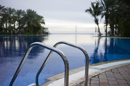 It is a very blue water pool  You can see palm trees and in the foreground a ladderのeditorial素材
