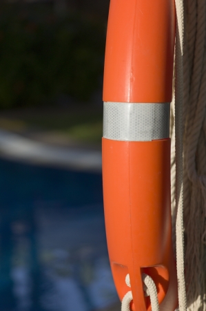 It is a rubber ring of orange color on the edge of a swimming poolの写真素材