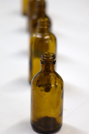 Row of small amber bottles on a white surfaceの写真素材