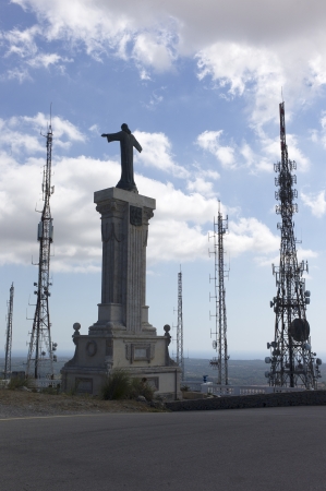 Statue of Christ surrounded by communication antennasの写真素材