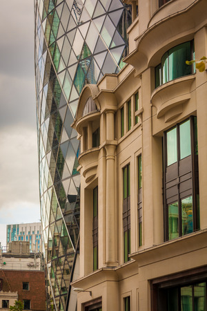 Archtectural contrast between the modern 30 St Mary Axe skyscraper and the older traditional buildings of the center of London, UK.のeditorial素材