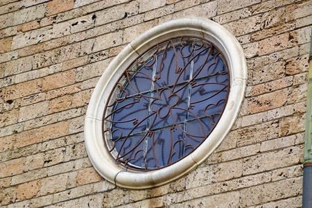 Close up of a grated circular window set into the stone exterior of a historic church in Sofia, Bulgariaの写真素材