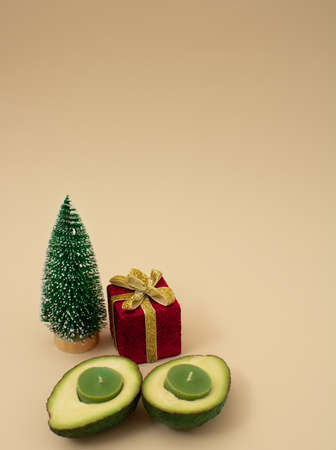 Christmas scene, creative winter accessories gift box, christmas tree on   color background.  New year and xmas decoration concept with copy space. Minimal colored and avocado with green candlesの写真素材