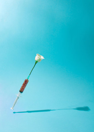 Creative Coronavirus or  or COVID-19 vaccine. Spring Nature creative idea. Epidemic virus Respiratory Syndrome. Syringe with white rose flowers. Minimal Pandemic background.の写真素材
