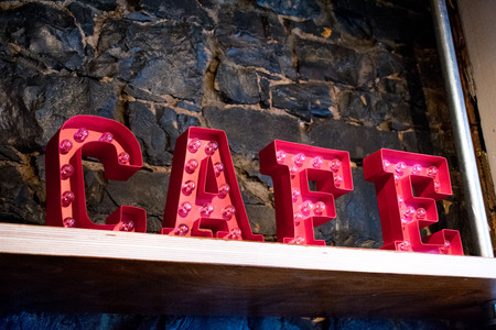 A bright red lit up sign of the word cafeの写真素材