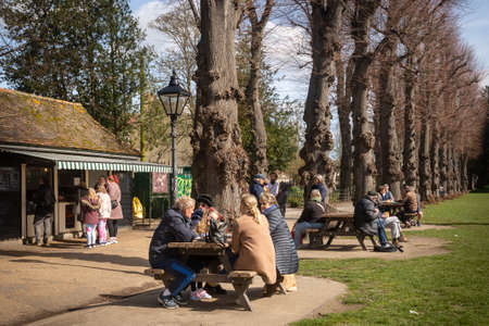 People enjoy a bright spring day at Dane John Gardens park in Canterbury, Kent, England.のeditorial素材