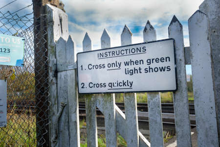 Railway crossing pedestrian warning sign advising when is safe to crossの写真素材