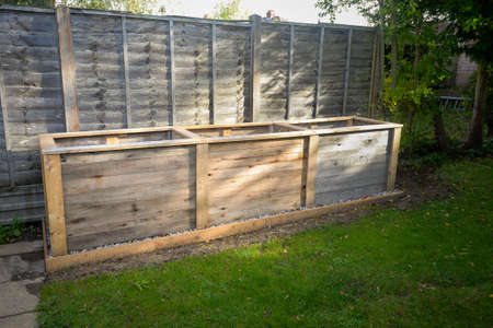 Empty timber tall deep root vegetable box planter ready for filling with compost and planting.