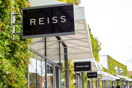 Reiss British fashion retail clothing store entrance sign at Ashford Outlet Center, Kent, England.