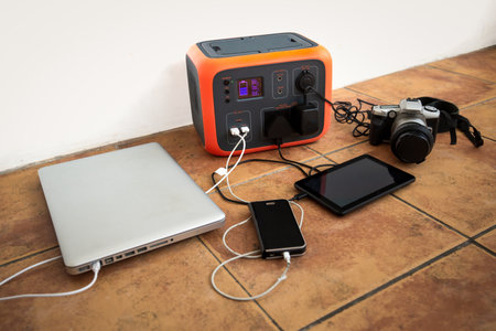 Portable power station solar electricity generator with laptop, phone, tablet and camera charging.