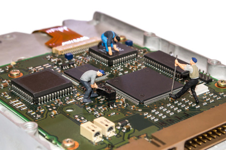 Miniature people repairing the hard drive A broken computer equipment. Figures of people. The team...