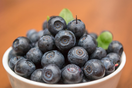 Blueberry in the white plate on the wooden table