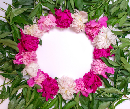 Round frame of peonies on a white background. Floral design. Pink and purple spring flowers. View from above, flat lay, top viewの写真素材