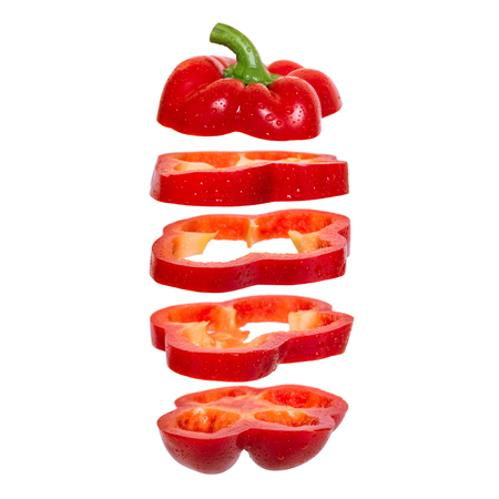 Creative concept with flying red paprika. Sliced floating pepper. Levity capsicum vegetable isolated...