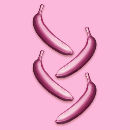 Purple metallic bananas on a pink background. A modern creative concept. Contemporary artの写真素材