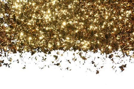 Golden flakes on a white background. Border of bright shining sequinsの写真素材