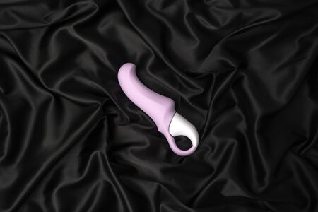 Purple sex toy on a black silk backgroundの写真素材