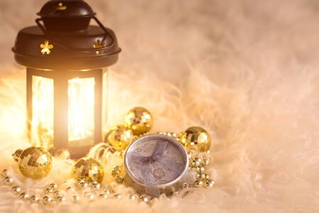 New Year's toys on white fur. Lantern, gold beads, gift box and disco balls. Christmas composition.