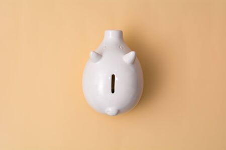 White pig piggy bank on a beige backgroundの写真素材
